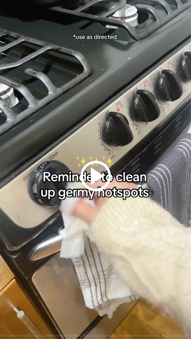 Hand wiping control knob of stove with caption, "Reminder to clean up germy hotspots."