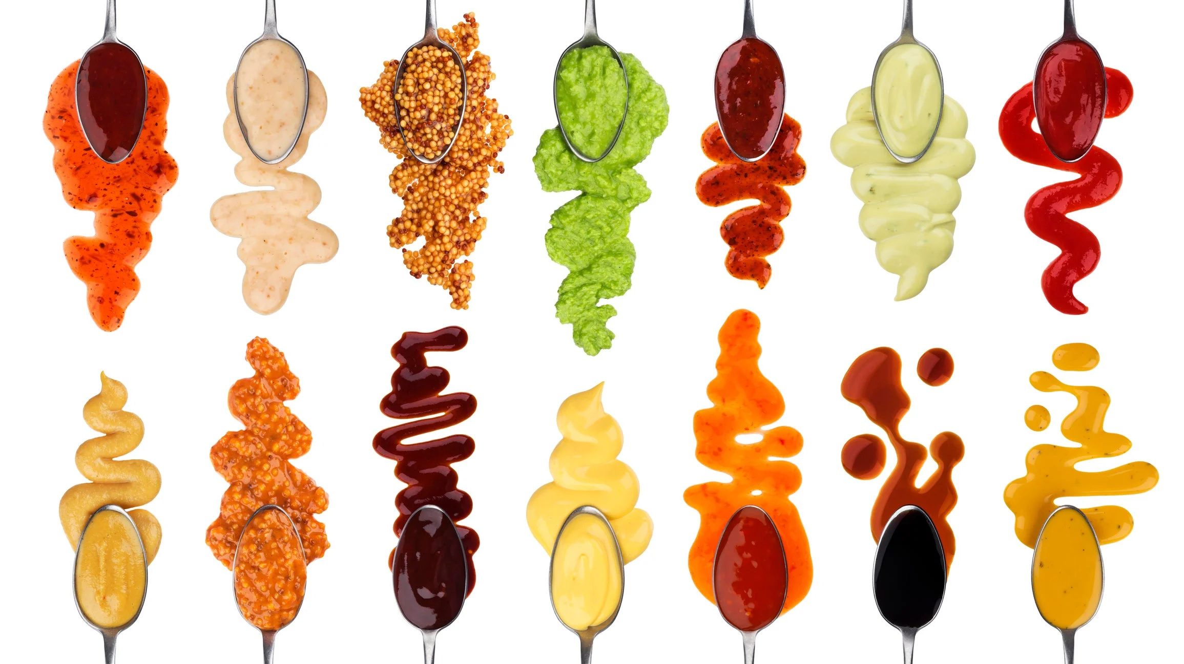 Artful display of different sauces on spoons, including mustard, ketchup, dressing, mayo.