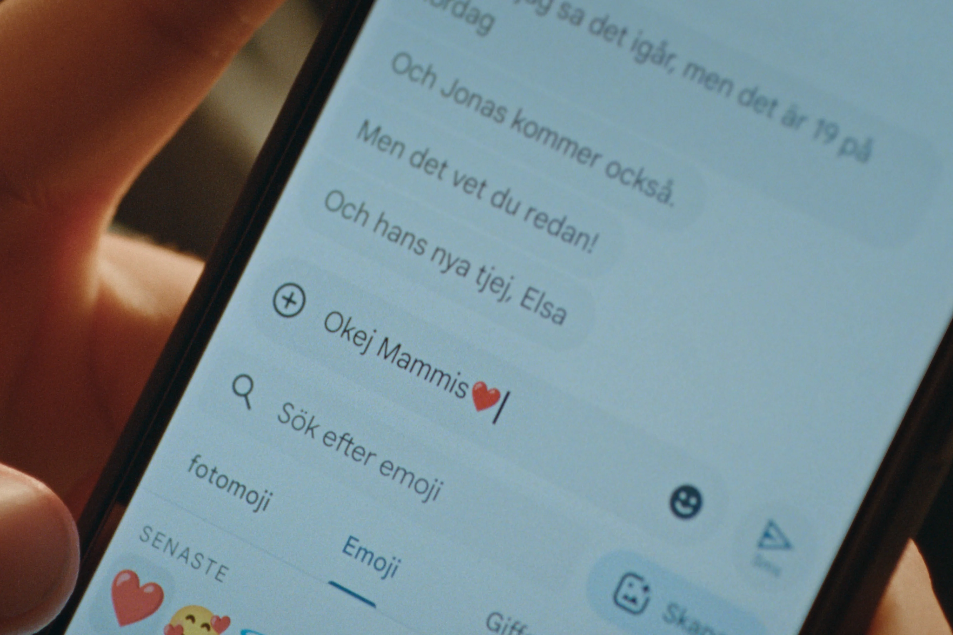 En närbild på en mobilskärm där någon skriver ett meddelande i en chattapp. Texten på skärmen lyder: "Okej Mammis❤️". Emojiväljaren är öppen och visar nyligen använda emojis.