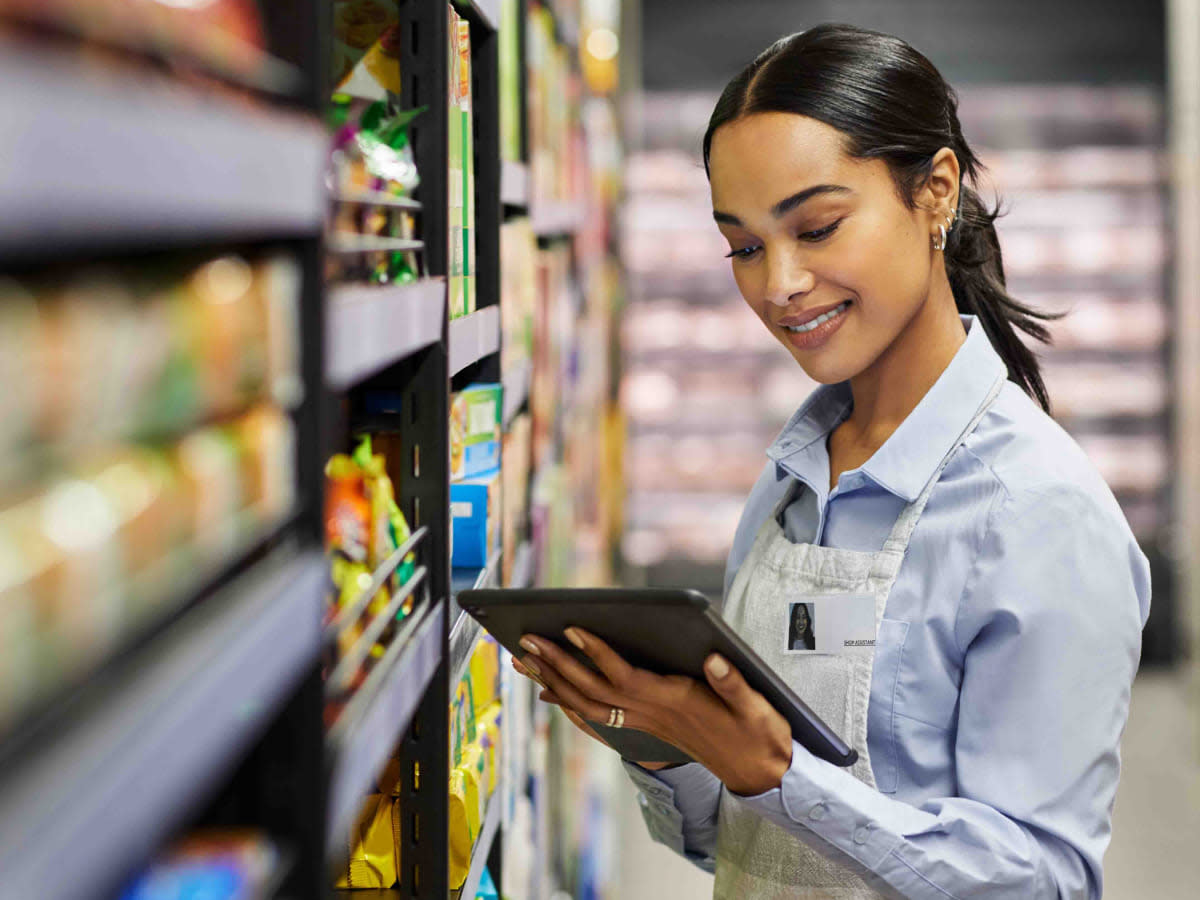 A woman uses a tablet exploring revenue growth management software and cpg analytics.